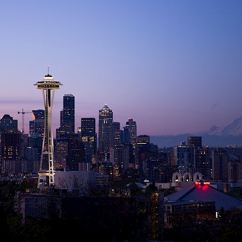 Seattle skyline at dusk with the Space Needle and Mount Rainier in the background.